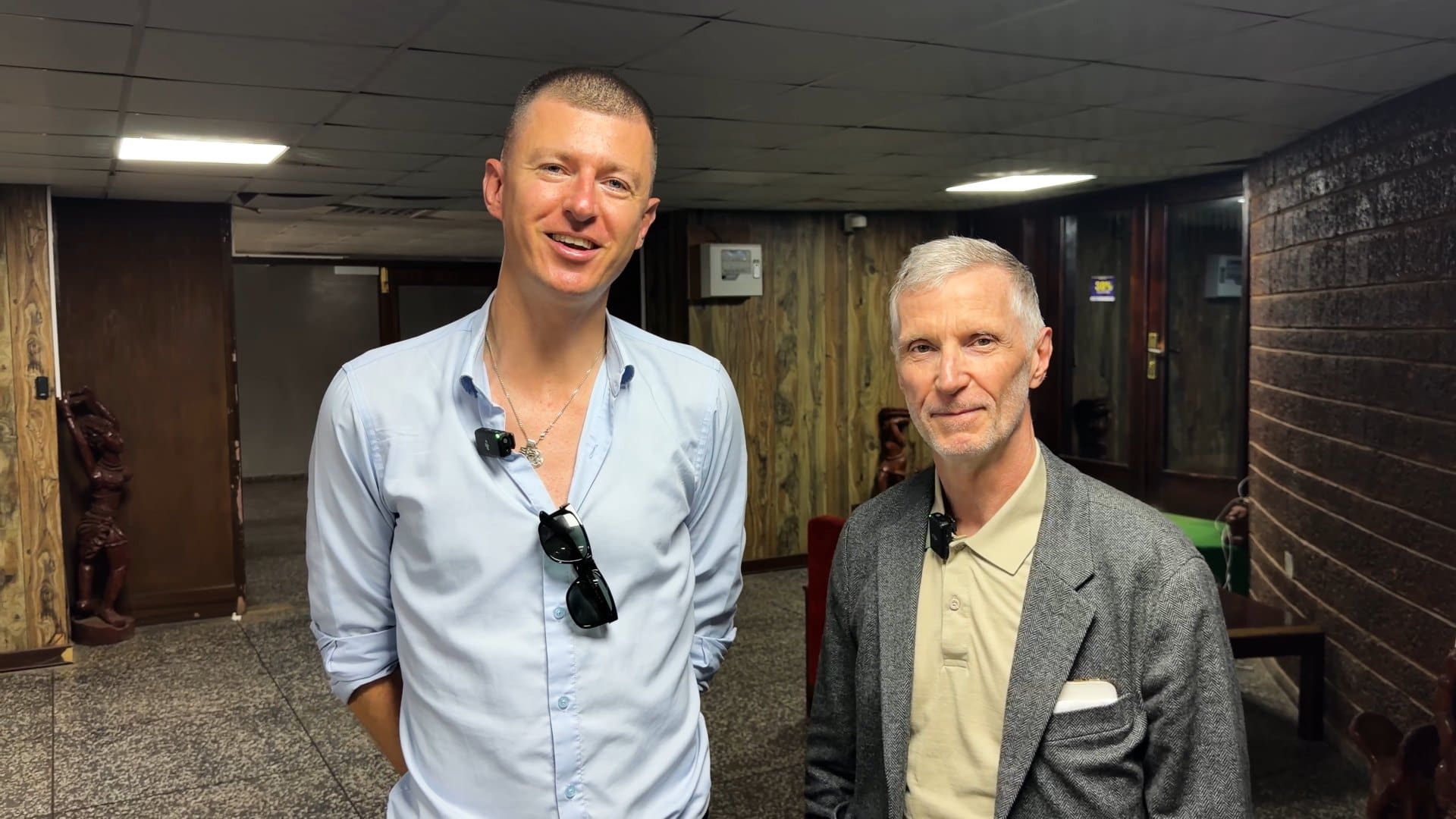 Ladislas Maurice and Stephen Barnes standing together indoors before a delegation meeting in Freetown.