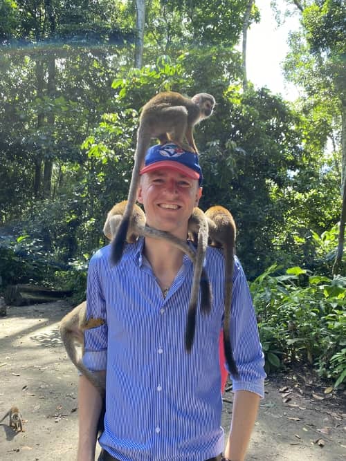Ladislas with three monkeys on his head Man standing with three monkeys on his head
